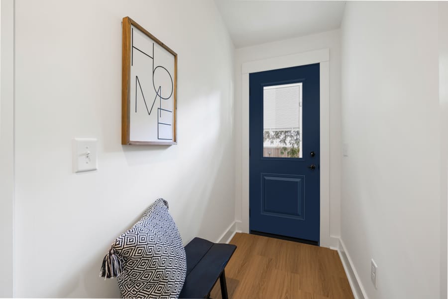 A royal blue steel entry door with white mini blinds sealed in the glass