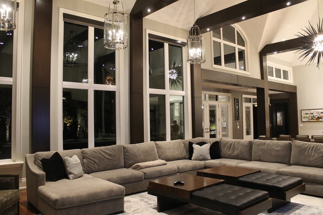 A double height living room with tall white framed windows and a transom above the entry